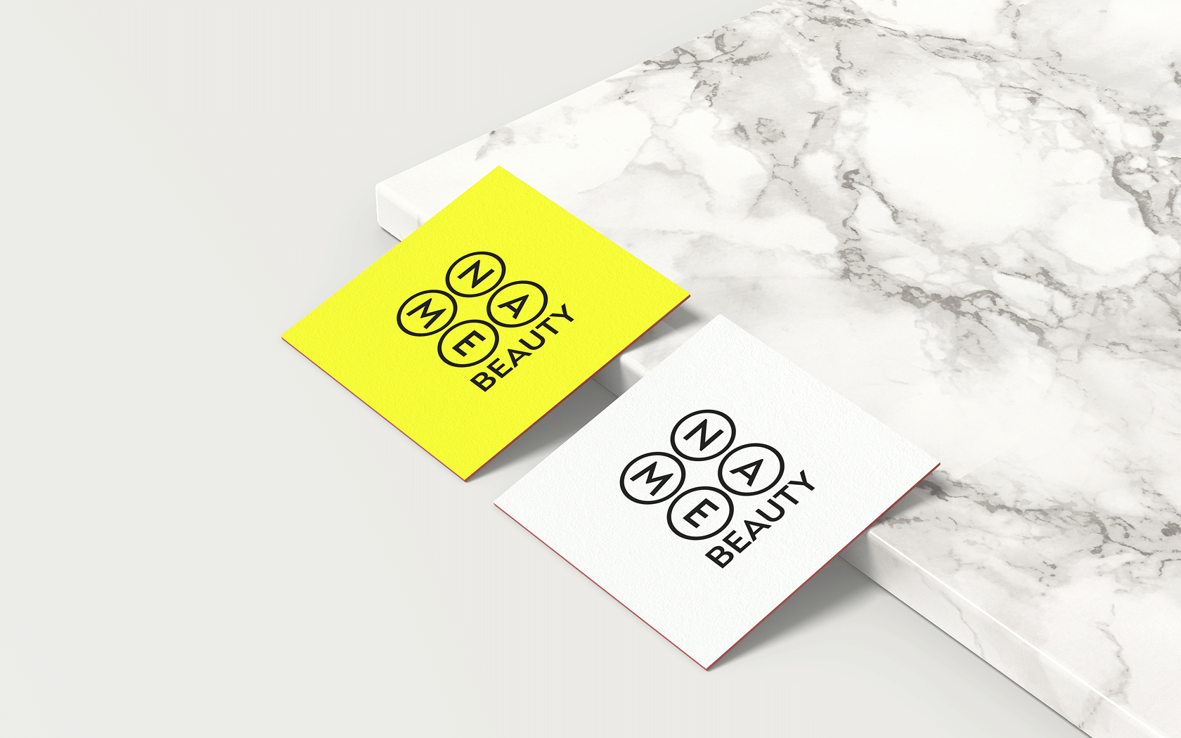 Головне зображення Name Beauty: мокап квадратних візиток (жовтої та білої) з логотипом на мармуровій поверхні - сучасний логотип для б'юті Київ