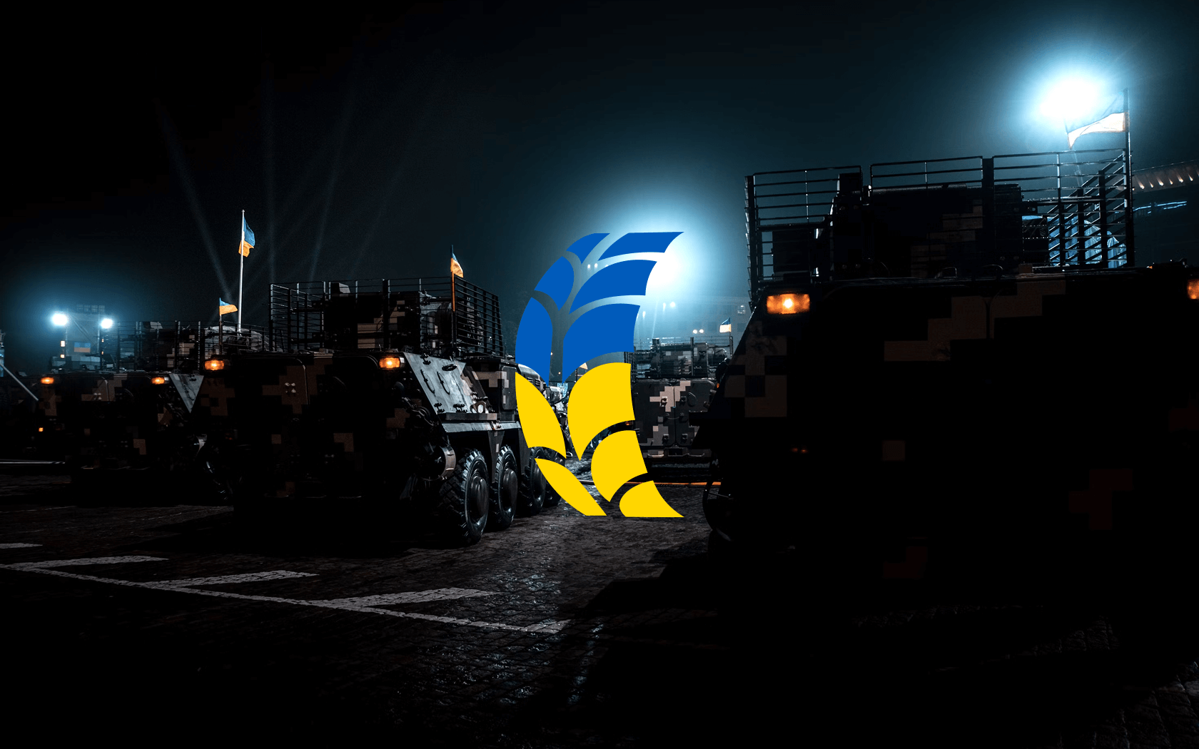 Головне зображення Ukraine Needs Wheels: логотип проекту на фоні військової техніки вночі - волонтерський проект для забезпечення транспортом ЗСУ, Київ, Україна