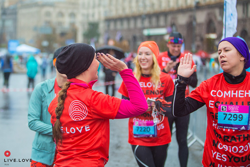 Учасники команди LIVE.LOVE Run у червоних футболках підтримують одне одного під час марафону в Києві