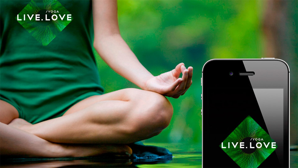 Жінка медитує на природі, поруч смартфон з логотипом додатку LIVE.LOVE Yoga