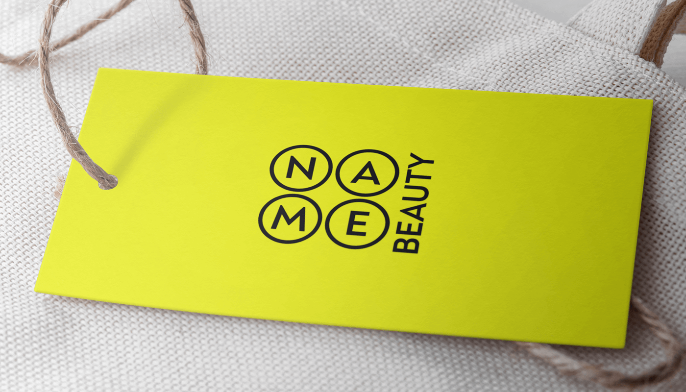 Мокап бірки Name Beauty: жовта бірка з логотипом на світлій тканині - бренд-ідентичність для косметичного бізнесу Київ