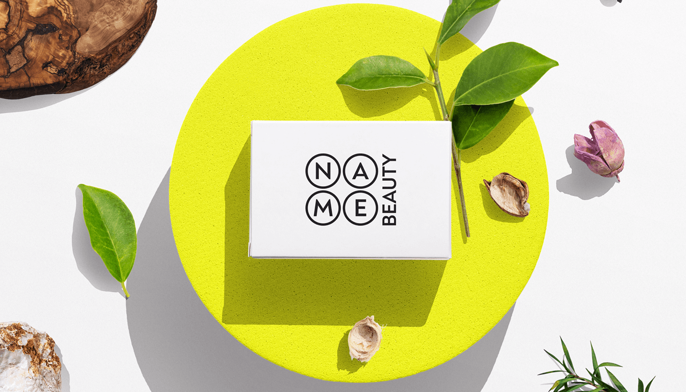 Мокап логотипу Name Beauty на жовтих візитках, що лежать на дерев'яній таці з пальмовим листом - унікальний дизайн для косметики Україна