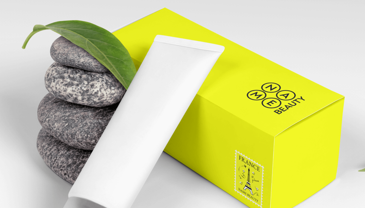 Мокап упаковки Name Beauty: біла коробка з логотипом на жовтому колі серед листя, деревини та пелюсток - унікальний дизайн для косметики Україна