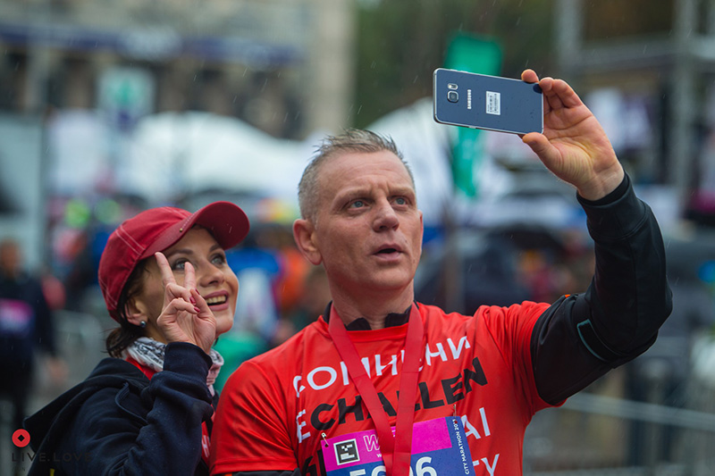 Учасники команди LIVE.LOVE Run у червоних футболках роблять веселе селфі після забігу на Київському марафоні